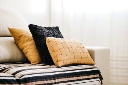Modern interior design featuring a comfortable sofa with decorative pillows and a striped throw.